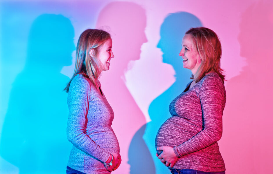 Foto van twee zwangere  zussen met bijzondere  gekleurde schaduwen, gemaakt met twee flitsers.