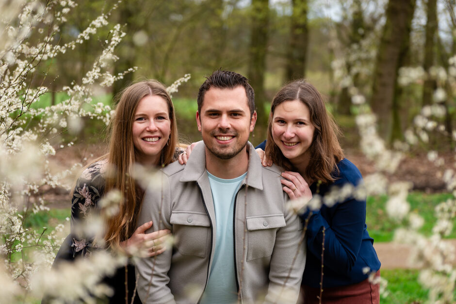 Portret van broer met zussen tussen takken met bloesem