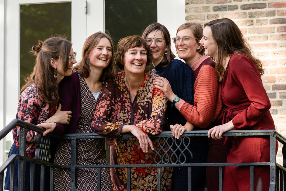 Zussen met mama op de foto bij de ballustrade van een balkon tijdens een familiefotoshoot te Baarlo.